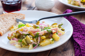 traditional german potato salad with sausage and pickled cucumbers, horizontal