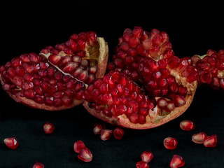 Fresh red pomegranate on dark background.