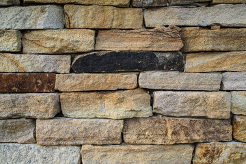 A wall of beautiful stone on the street. Background. Texture.
