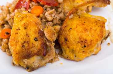 Closeup of tasty  chicken thighs with pearl barley  at plate