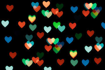 Multicoclerd hearts bokeh on black background