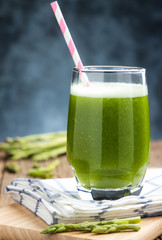 Healthy green smoothie asparagus on cutting board and wooden background. food and drink for health concept.