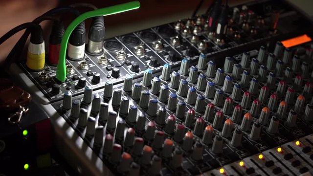 Old sound engineer console. Dolly shot of an old sound board, mixing console with nobs