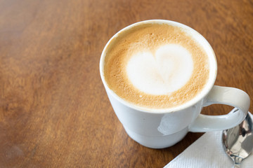 View of Coffee latte art on wooden table.