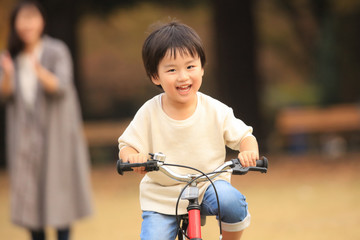 Obraz premium 自転車に乗る練習をする親子