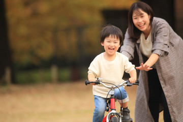 自転車に乗る練習をする親子