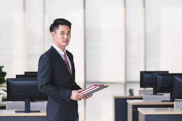 Businessman holding notebook computer in office..