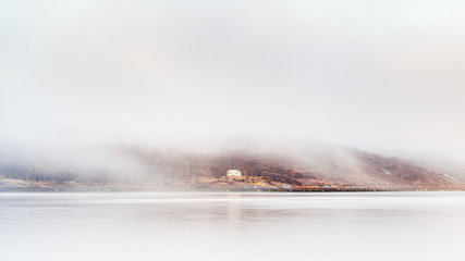 Kirkenes Coastline.  A home shrouded in mist viewed from the Kirkenes coastline.  Kirkenes is a town located in Northern Europe close to the Russian border.