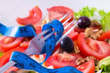 lettuce and tomato salad with tape measure, healthy diet concept