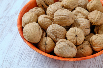 Wood plate with nuts on white wood.