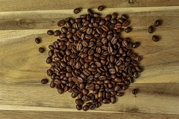 Pile of coffee beans on a wooden background