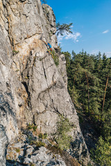 Climber climbing on a rock face. An alpinist ascending big rock clif. Sport and rock climbing, extreme outdoor sport. Sandstone traditional climbing.