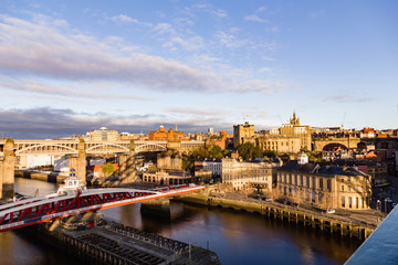Fototapeta na wymiar At sunrise a shadow from the iconic Tyne Bridge is cast across Newcastle Upon Tyne's Quayside and Grainger town areas
