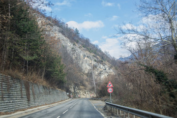 Beautiful mountain road in Bulgaria, Rhodopi mountain, wintertime car road with trees and rocks on the side