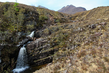 Waterfall cascades down the side of the Torridon mountain range on the west coast of Scotland