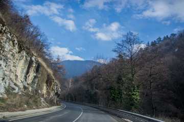 Beautiful mountain road in Bulgaria, Rhodopi mountain, wintertime car road with trees and rocks on the side