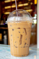 Coffee in plastic glass on the table at coffee shop.