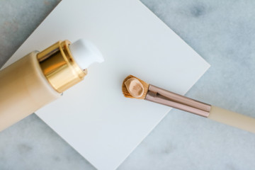 Makeup foundation bottle and contouring brush on marble, make-up concealer bb cream as cosmetics...