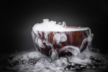 Smoke from dry ice in a wooden bowl, dark background - obrazy, fototapety, plakaty