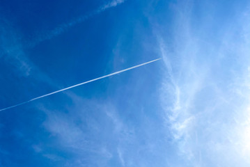 Trail of white smoke from the airplane on the blue sky and could. An airplane jets through a clear...