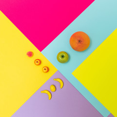 Juicy laid out fruit on geometric colorful background. Conceptual minimalism. Flat lay
