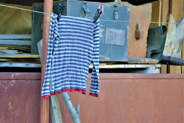 Fototapeta na wymiar an old striped vest hangs on a rope