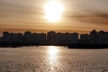 Evening sunset in the city on the bay in a frosty autumn day, golden lighting