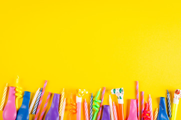 Colored candles and air balloons composition on yellow background, party and celebration decoration.