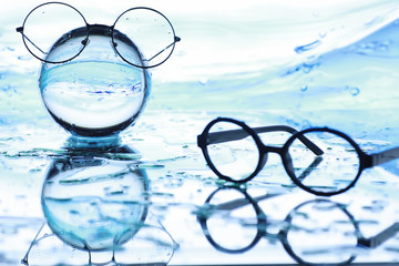 Fototapeta na wymiar Tools for vision correction. Glasses and lenses with diopters on the background of splashes and blurry.