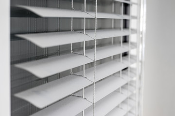 white window blinds with reflections on the glass