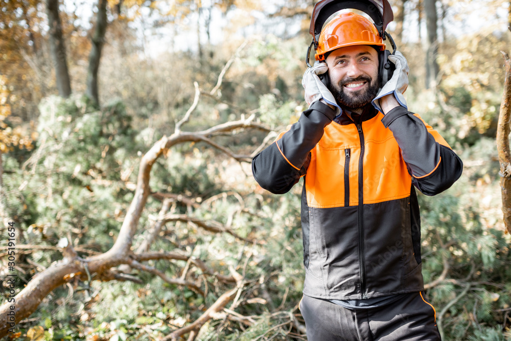 Wall mural waist-up portrait of a professional lumberman wearing protective clothes, preparing for logging work