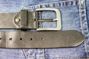 Black leather belt on Jeans pocket background