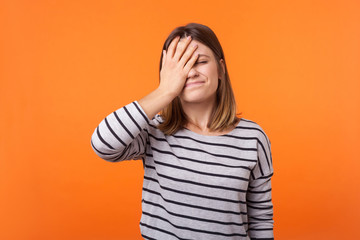 Facepalm. Portrait of forgetful upset woman with brown hair in long sleeve shirt standing covering...