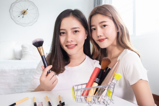 Portrait of young asian woman review giveaway gift product fan following channel, recording video make up lipstic cosmetic at home. Beauty blogger present beauty cosmetics