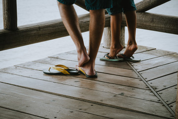 two pair of legs wearing brazilian flipflops / sandals
