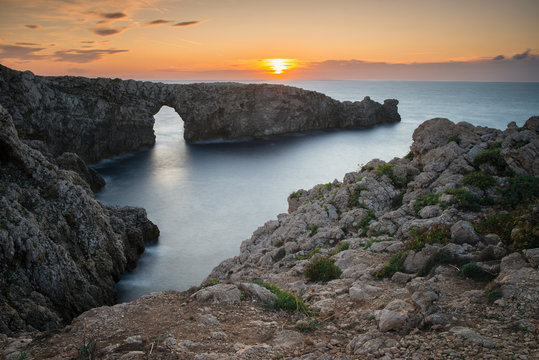 Coucher de soleil à Pont d'en Gil, arche naturelle à côté de Ciutadella de Menorca, îles Baléares, Minorque, Espagne