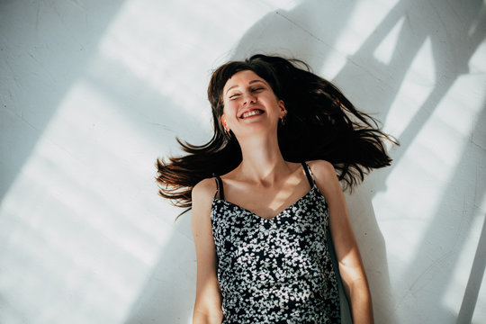 carefree brunette woman lying on the floor laughing