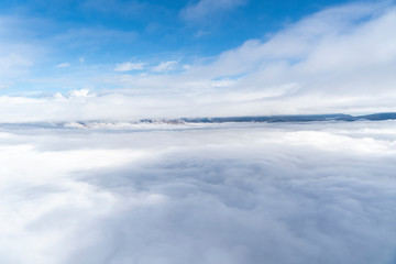 views of the mountains, clouds and fog below during a hot air balloon flight in La Cerdanya, Catalonia