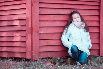 Obraz na płótnie Canvas Beautiful girl sitting near the red arbor.