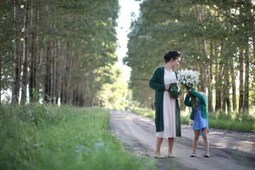 Fototapeta premium Mother with daughter walking on a road
