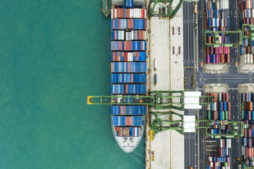 Fototapeta na wymiar View from above, stunning aerial view of the port of Singapore with hundreds of colored containers ready to be loading on the cargo ships. The Port of Singapore is the second biggest port in the world