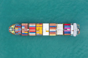 View from above, stunning aerial view of a cargo ship sailing with hundreds of colored containers...