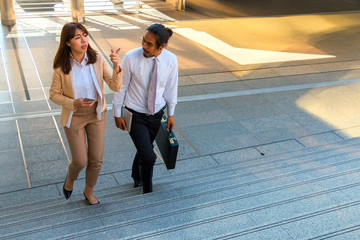 Two young business walking in city and talking about his project