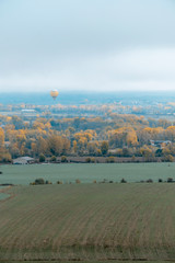 aerostatic balloon among the clouds, above the town in the area of Cerdanya, in Catalonia