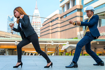 Fototapeta premium Business people stretching the rope with cityscape background.