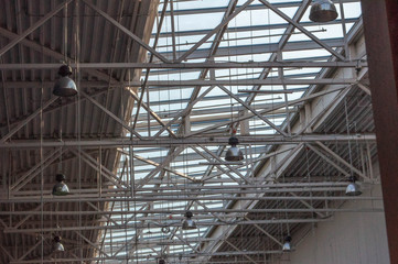 a ceiling in a production hall with a large svent window and luminaires suspended on long rods