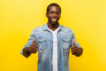 Thumbs up, excellent job! Portrait of enthusiastic handsome man in denim casual shirt with rolled...