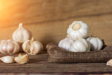 Garlic cloves and bulb in cloth vintage. Garlic cloves on rustic table in wooden bowl. Fresh peeled garlic and bulbs.
