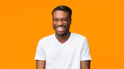 African American Guy Laughing Standing On Orange Background, Panorama