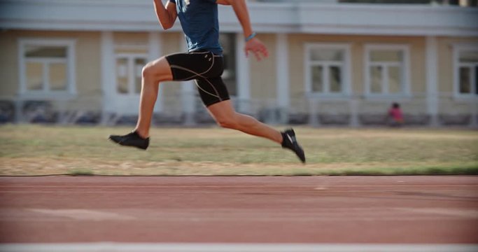 Professional asian athlete running, sprinting on a stadium track, training before a tournament - healthy way of life, sports concept 4k footage